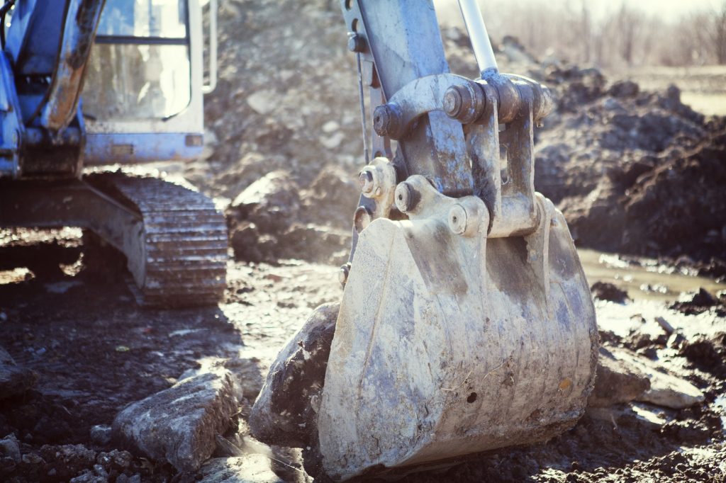 Earth Mover Digging Land At Construction Site