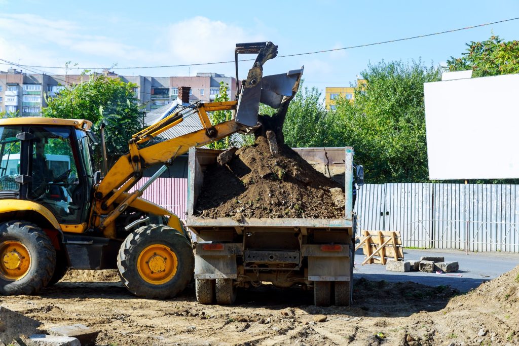 yellow excavator at sandpit during earthmoving works excavator digs the road